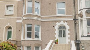 A corner building with a curved facade, multiple windows, and a small entrance with a door.