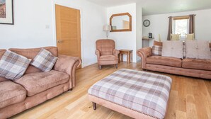 A living room with two sofas, a chair, and a small table.