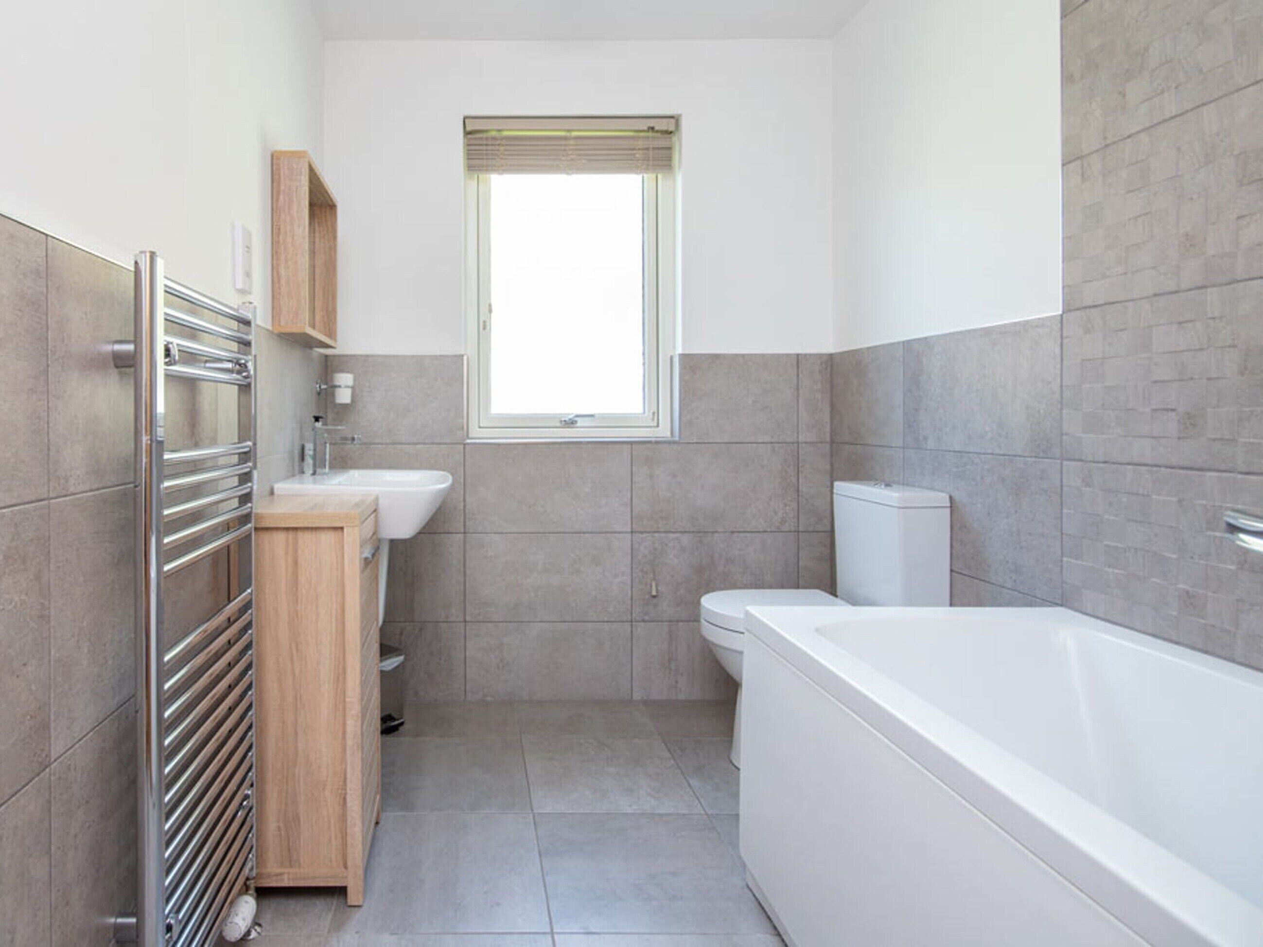 A modern bathroom with a bathtub, a sink, and a toilet.