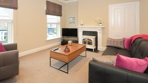 A living room with a fireplace, a television, and a sofa. - 1 bedroom accommodation in York (York)