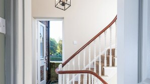 A hallway leading to a staircase with a wooden handrail and white balusters. - 3 bedroom accommodation in York (York)