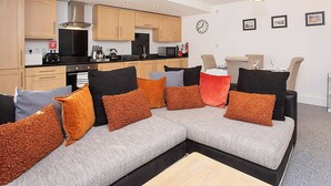 Een modern appartement met keuken, eethoek en woonkamer.
