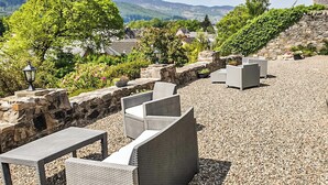Terraza al aire libre con muros de piedra y vistas a montañas.