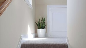 A staircase with a white door and a potted plant at the landing. - Oakbank Cottage - UK7574 (Pitlochry)
