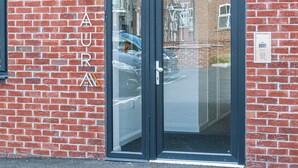 Un edificio de ladrillo con puerta de cristal y cerradura electrónica.