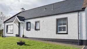 A white house with a grey roof, a front door, and three windows. - Willow Cottage - UK30684 (Sandhead)