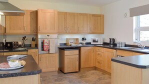 Une cuisine moderne avec des meubles en bois, des appareils en acier inoxydable et un plan de travail en granit.