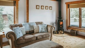 A cozy living room with a brown leather sofa, a fireplace, and framed pictures on the wall. - Rawlsbury Lodge - UK31007 (Ansty, near Dorchester)