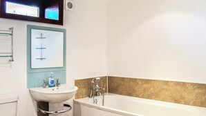 Un baño con inodoro, lavamanos y bañera.
