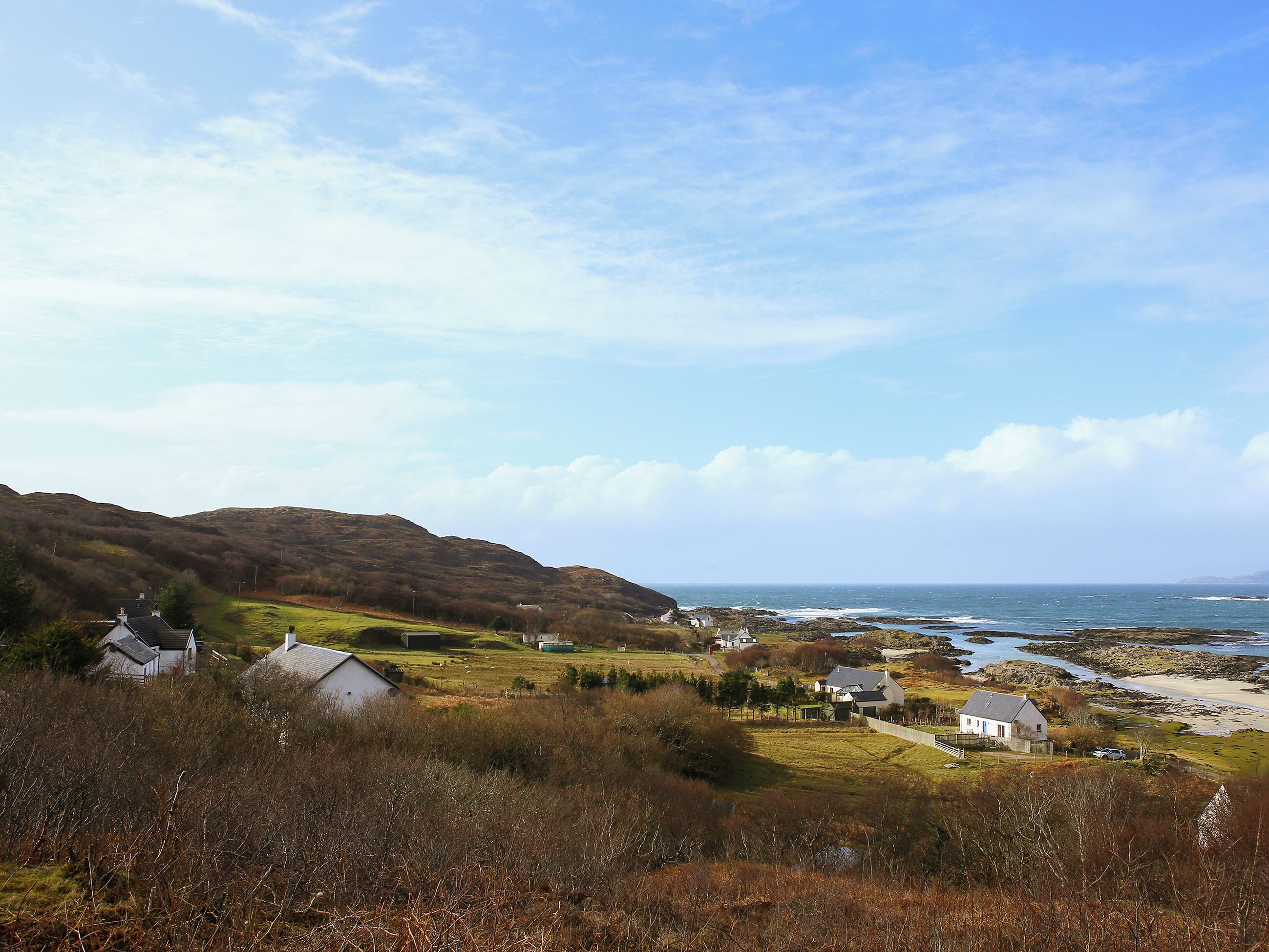 A coastal village with houses and a beach.