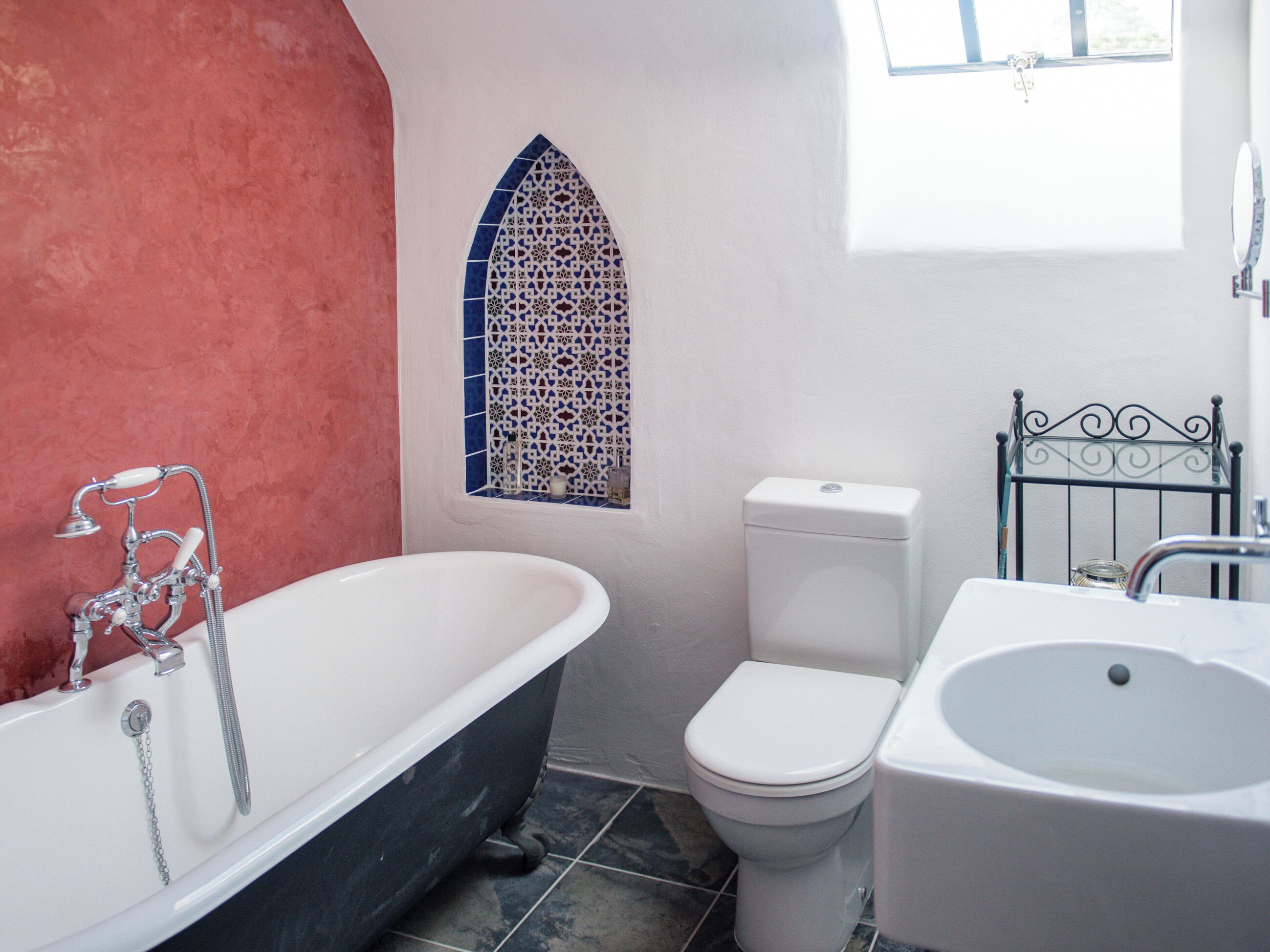 A bathroom with a freestanding bathtub, a toilet, and a sink.