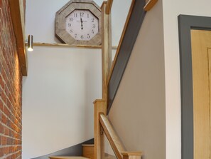 A wooden staircase with a clock on the wall. - 3 bedroom accommodation in Swafield, near North Walsham (Swafield, near North Walsham)