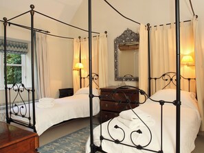 A four-poster bed with a mirror above it, a wooden dresser, and a window with curtains. - 3 bedroom accommodation in Bruern, near Chipping Norton (Bruern, near Chipping Norton)