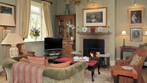 A traditional living room with a fireplace, television, and comfortable seating. - This truly unique property will appeal to guests looking for a touch of luxury. (Bruern, near Chipping Norton)