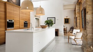A modern kitchen with a central island, wooden cabinets, and pendant lighting. - 4 bedroom accommodation in Longframlington, near Rothbury (Longframlington, near Rothbury)