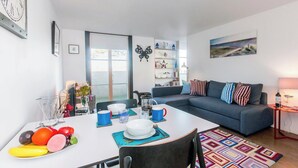 Een moderne woonkamer met een eettafel, een bank en een boekenkast.