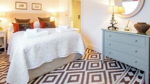 A hotel room with a bed, bedside lamps, a dresser, and a mirror. - 1 bedroom accommodation in Thorpeness, near Aldeburgh (Thorpeness, near Aldeburgh)