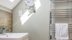 A bathroom with a white sink, a mirror, and a towel rack. - 5 bedroom accommodation in Dunholme, near Lincoln (Dunholme, near Lincoln)