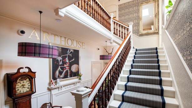 A staircase with a patterned carpet, a wooden banister, and a wall-mounted clock. - Fabulous luxurious bolthole in the centre of Inverness. (Inverness)