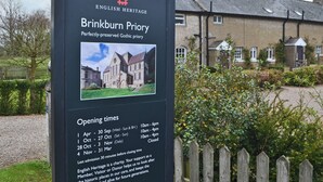 A sign for Brinkburn Priory, a Gothic priory, with opening times listed. - 2 bedroom accommodation in Longframlington, near Rothbury (Longframlington, near Rothbury)