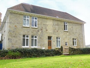 A two-story stone building with a tiled roof, multiple windows, and a front door. - 2 bedroom accommodation in Shanklin (Shanklin)