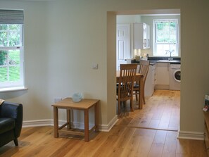 A kitchen with a dining area, wooden flooring, and a view of the outdoors. - Highlands Apartment 2 - UKC2900 (Shanklin)