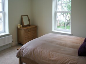 A bedroom with a bed, a dresser, and two windows. - Highlands Apartment 2 - UKC2900 (Shanklin)