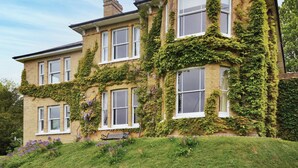A Victorian-style building with multiple windows, ivy-covered walls, and a bench in the front garden. - 6 bedroom accommodation in Brading, near Sandown (Brading, near Sandown)