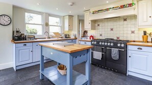 A kitchen with a central island, a stove, and a variety of kitchen appliances. - 6 bedroom accommodation in Brading, near Sandown (Brading, near Sandown)