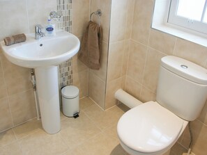 A bathroom with a white sink, a toilet, and a small trash bin. - Highlands Apartment 3 - UKC3105 (Shanklin)