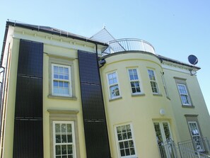A multi-story building with a curved facade, large windows, and a satellite dish. - Highlands Apartment 3 - UKC3105 (Shanklin)