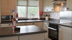 A modern kitchen with a granite countertop, stainless steel appliances, and wooden cabinetry. - 2 bedroom accommodation in Forres, near Nairn (Forres, near Nairn)