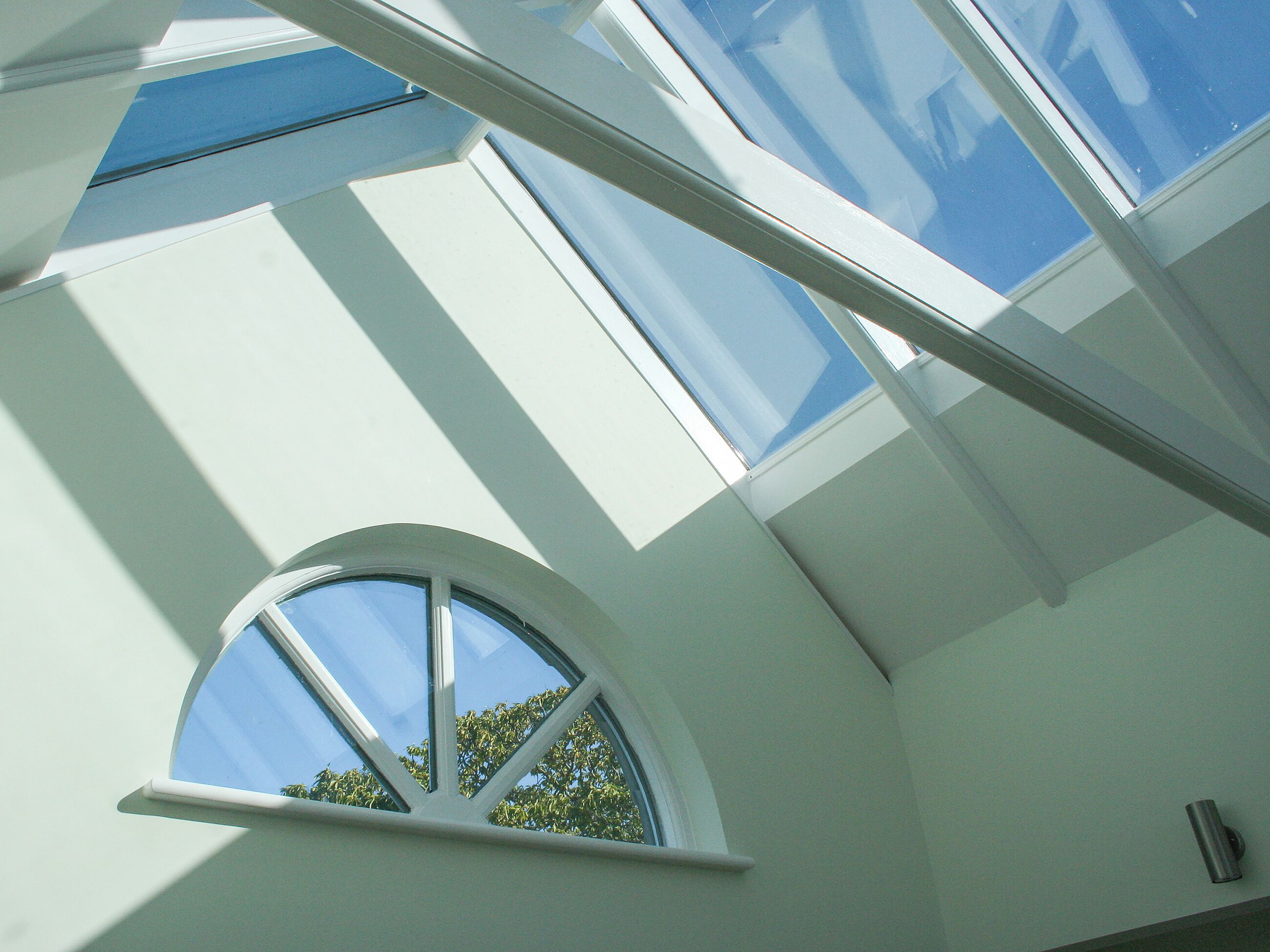 A skylight window with a view of the sky and trees.