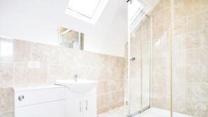 Un baño moderno con ducha, inodoro y lavamanos.