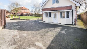 A two-story house with a front porch, a driveway, and a fenced yard. - 2 bedroom accommodation in Murton, near York (Murton, near York)