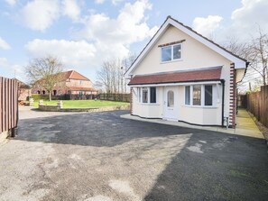 A two-story house with a front porch, a driveway, and a fenced yard. - 2 bedroom accommodation in Murton, near York (Murton, near York)