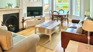 Un salon avec une cheminée, un téléviseur, une table à manger et un coin salon.