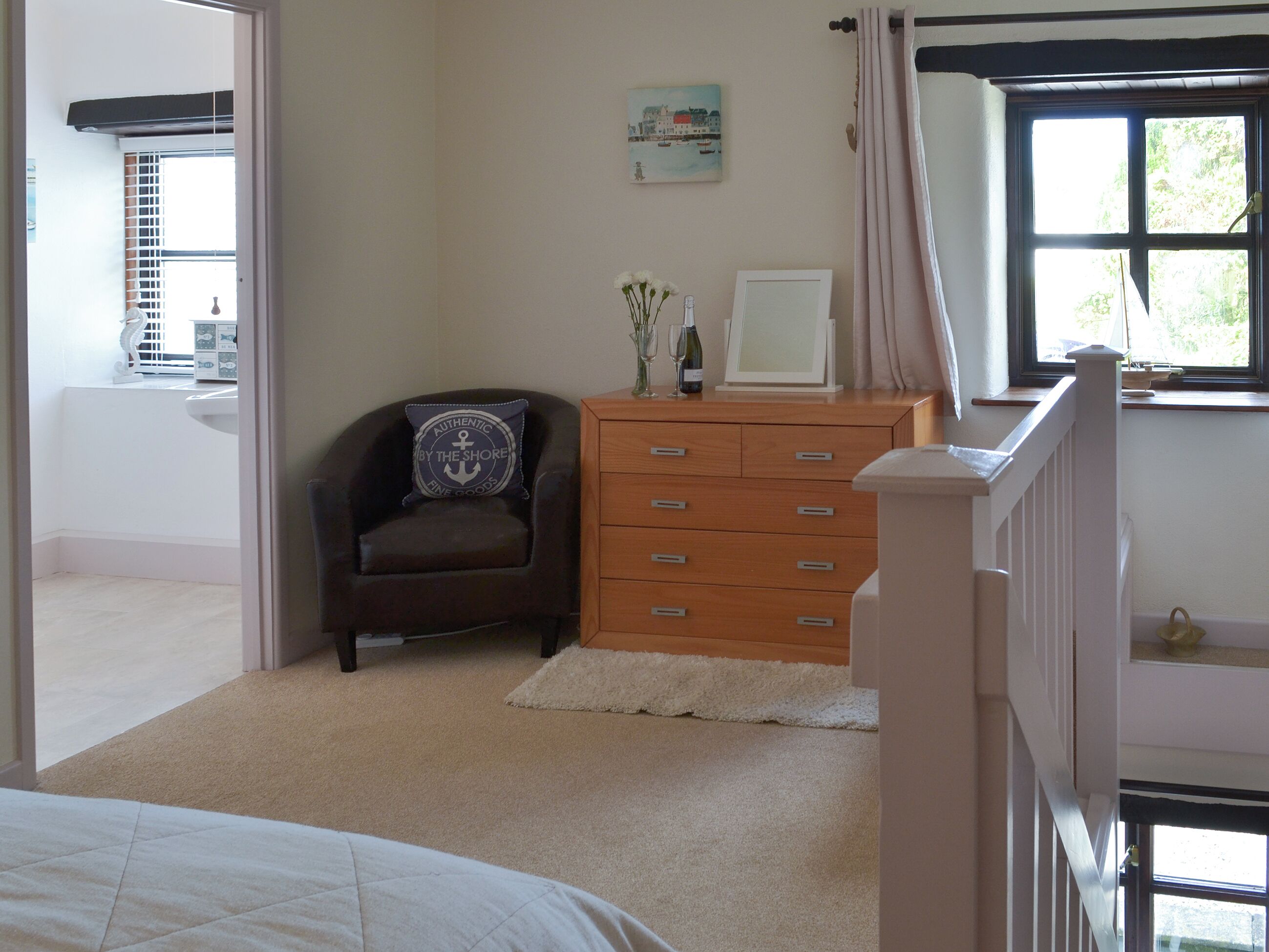 A bedroom with a bed, a dresser, a chair, a window, and a painting on the wall.