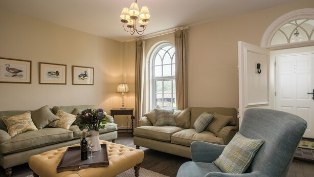 A living room with two sofas, a coffee table, a lamp, and framed artwork on the wall. - 3 bedroom accommodation in Worstead, near North Walsham (Worstead, near North Walsham)