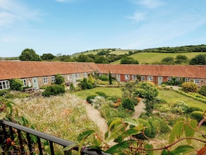 A row of traditional cottages with a garden in front, surrounded by rolling hills. - Shepherd's Cottage - UKC3954 (Chilcombe, near Bridport)