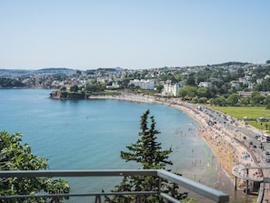 Eine Küstenstadt mit Strand, Uferpromenade und Wohnhäusern.