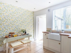 A kitchen with a breakfast setup, a window with blinds, and a door leading outside.