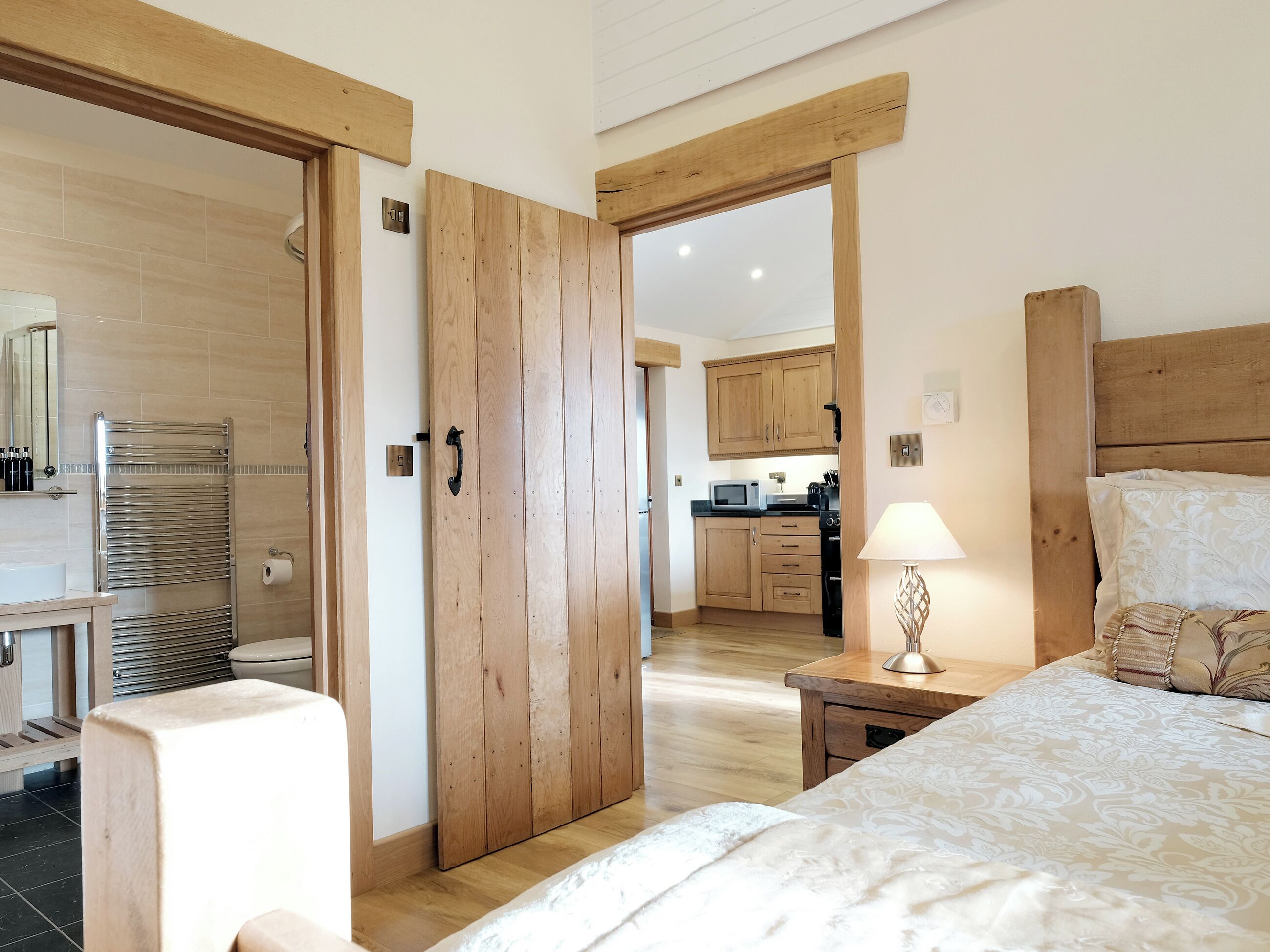 Ein Schlafzimmer mit einem Bett, Nachttisch, Lampe und einem Holzschrank.