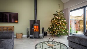 En stue med pejs, juletræ og to sofaer.