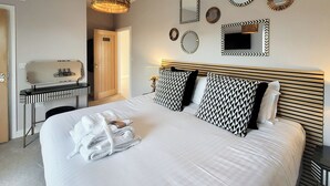 Ein Hotelzimmer mit Bett, Nachttisch und Spiegel.