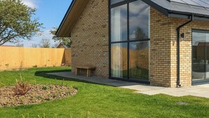 A modern house with a sloped roof, large glass windows, and a brick exterior. - Bailgate Barn - UKC4646 (Dunholme, near Lincoln)