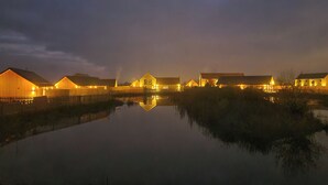 Een reeks gebouwen met een rustig waterlichaam op de voorgrond, dat de constructies weerspiegelt.