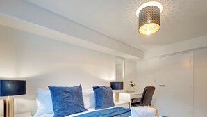 Una habitación de hotel moderna con una cama bien hecha, un escritorio y una silla.