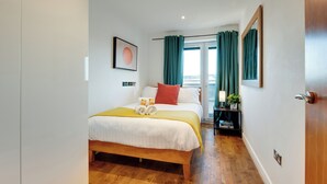 A hotel room with a bed, a nightstand, a window with curtains, and a view of the outside. - 2 bedroom accommodation in Newcastle Upon Tyne (Newcastle Upon Tyne)