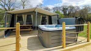 A camping site with a tent, a hot tub, and a wooden deck. - 2 bedroom accommodation in Rhayader and the Elan Valley (Rhayader and the Elan Valley)